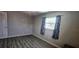 Bedroom featuring wood-look floors, large window with curtains, and neutral colored walls at 570 Mimosa Nw Ave, Port Charlotte, FL 33952