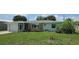 Inviting single-story home with lush lawn, stone details, and an attached one car garage at 570 Mimosa Nw Ave, Port Charlotte, FL 33952