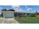 Charming single-story home with a well-maintained lawn, stone accents, and attached garage at 570 Mimosa Nw Ave, Port Charlotte, FL 33952