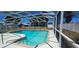 Screened in pool with bright blue water and surrounded by new landscaping at 570 Mimosa Nw Ave, Port Charlotte, FL 33952