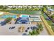 Aerial view of community pool, tennis, shuffleboard, clubhouse with solar panels, parking, and waterfront access at 6144 Redwing Ave, Englewood, FL 34224