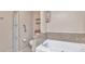 Bathroom features a white soaking tub, decorative walls, and built in shelves for storage at 6144 Redwing Ave, Englewood, FL 34224
