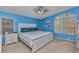 Main bedroom with blue accent wall, neutral carpet, a ceiling fan and white furniture at 6144 Redwing Ave, Englewood, FL 34224