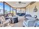 Enclosed sunroom featuring a ceiling fan, and multiple seating areas offers indoor-outdoor living at 6144 Redwing Ave, Englewood, FL 34224