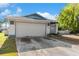 Home exterior with white garage door, trimmed with blue at 6604 Ranger Dr, Tampa, FL 33615