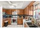 Well-lit kitchen featuring wood cabinetry, granite countertops, and modern appliances at 6604 Ranger Dr, Tampa, FL 33615