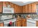 Kitchen with ample wood cabinets, white appliances and countertops at 6604 Ranger Dr, Tampa, FL 33615