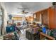 A cluttered living room featuring a ceiling fan, wood paneling, and various household items, showcasing the home's interior at 6604 Ranger Dr, Tampa, FL 33615