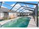 A screened-in swimming pool with a concrete deck, showcasing a private outdoor recreation space at 6604 Ranger Dr, Tampa, FL 33615