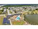 Expansive aerial view of a community with a pool, lake, parking, and various homes in a scenic, sunny location at 6753 Thorman Rd, Port Charlotte, FL 33981