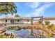 A tranquil backyard features a rock-lined pond with a swing set near the white fence and patio at 6753 Thorman Rd, Port Charlotte, FL 33981