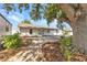 Exterior of the home shows the private outdoor patio and landscaped grounds with a tree at 6753 Thorman Rd, Port Charlotte, FL 33981