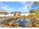 Beautiful backyard featuring a rock-lined pond with a wooden swing set and brick-paved patio at 6753 Thorman Rd, Port Charlotte, FL 33981