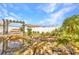 Scenic backyard showcases a pond with rock accents and a swing set, surrounded by lush greenery at 6753 Thorman Rd, Port Charlotte, FL 33981