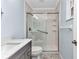 Bathroom featuring glass door walk-in shower, grey vanity with stainless steel faucet and light blue walls at 6753 Thorman Rd, Port Charlotte, FL 33981