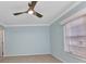 A bedroom featuring neutral carpet, modern ceiling fan and light blue walls at 6753 Thorman Rd, Port Charlotte, FL 33981