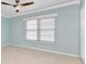 Bright bedroom with neutral carpet, ceiling fan and natural light from a window with blinds at 6753 Thorman Rd, Port Charlotte, FL 33981