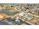 Aerial view of community pool, tennis courts, clubhouse, and parking surrounded by homes and a pond at 6753 Thorman Rd, Port Charlotte, FL 33981