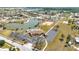 Aerial view of the community pool, tennis courts, parking, and pond in a residential neighborhood at 6753 Thorman Rd, Port Charlotte, FL 33981