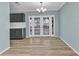 Dining room with grey cabinets, wood flooring, chandelier and french doors leading to outdoor space at 6753 Thorman Rd, Port Charlotte, FL 33981