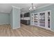 Open dining room with wood flooring, french doors and view of kitchen with grey cabinets at 6753 Thorman Rd, Port Charlotte, FL 33981