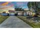 Beautiful sunset view of a single-story home with lush front yard, attached garage, and welcoming front entrance at 6753 Thorman Rd, Port Charlotte, FL 33981