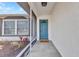 Inviting covered front porch with a blue door, stylish gray tile flooring, and decorative plants at 6753 Thorman Rd, Port Charlotte, FL 33981