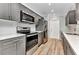 Modern kitchen features gray cabinets, stainless steel appliances, white countertops and wood-look floors at 6753 Thorman Rd, Port Charlotte, FL 33981