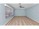 Spacious living room featuring modern ceiling fan, light blue walls, and sleek light wood flooring at 6753 Thorman Rd, Port Charlotte, FL 33981