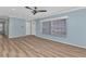Open living room with modern ceiling fan, light blue walls, and sleek light wood flooring at 6753 Thorman Rd, Port Charlotte, FL 33981