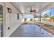 Covered patio with a ceiling fan, featuring a large backyard and manicured landscaping at 6753 Thorman Rd, Port Charlotte, FL 33981