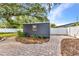 Backyard shed with a brick paver path, surrounded by mature landscaping and a white fence at 6753 Thorman Rd, Port Charlotte, FL 33981