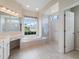 Bathroom with a large tub, glass shower, and vanity with plenty of counter space at 857 Macaw Cir, Venice, FL 34285