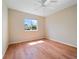 Bright bedroom with wood floors, a ceiling fan, base molding, and a window at 857 Macaw Cir, Venice, FL 34285