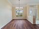 Dining room with hardwood floors, a chandelier, and natural lighting from the windows offering an outdoor view at 857 Macaw Cir, Venice, FL 34285