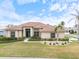 Charming home featuring lush green lawn and landscaping at 857 Macaw Cir, Venice, FL 34285