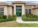 Charming home entrance with well-manicured landscaping, a walkway, and a stylish front door at 857 Macaw Cir, Venice, FL 34285