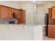 Kitchen showcasing breakfast bar, tile floors, stainless steel appliances and warm wood cabinets at 857 Macaw Cir, Venice, FL 34285