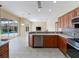Charming kitchen with stainless steel appliances, wood cabinets, and an eat-in counter adjacent to a living space and sliding glass door at 857 Macaw Cir, Venice, FL 34285