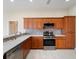 Well-equipped kitchen featuring modern appliances, light countertops and wooden cabinets at 857 Macaw Cir, Venice, FL 34285