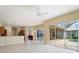 Spacious living room with tile flooring, ceiling fan, recessed lighting, and sliding glass doors that lead to an outdoor patio and pool at 857 Macaw Cir, Venice, FL 34285
