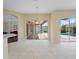 Open living room with tile floors, fan, and a sliding glass door that leads to an outdoor patio and pool at 857 Macaw Cir, Venice, FL 34285