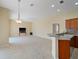 Open living room with tile floors, fan, and a partial view of the kitchen bar and access to the side of the house at 857 Macaw Cir, Venice, FL 34285
