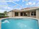 Relaxing screened-in pool area with large patio and beautiful blue tile and tranquil water at 857 Macaw Cir, Venice, FL 34285