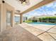 Covered lanai with brick pavers overlooks the screened-in pool and lush landscaping at 857 Macaw Cir, Venice, FL 34285