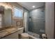 Beautiful bathroom features blue tiled shower with seat, granite countertop vanity, and natural light at 9390 Little Gasparilla Island, Placida, FL 33946