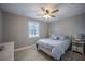 Bright bedroom with a ceiling fan, large window with blinds, and a comfortable bed with blue accents at 9390 Little Gasparilla Island, Placida, FL 33946