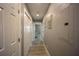A well-lit hallway featuring neutral wall colors, paneled doors, and light-colored wood floors at 9390 Little Gasparilla Island, Placida, FL 33946