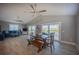 Spacious living and dining area showcasing wood floors, ceiling fan, deck access, and comfortable furnishings at 9390 Little Gasparilla Island, Placida, FL 33946