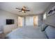 A cozy bedroom with a neutral color palette, ceiling fan, and adjacent bathroom and closet at 9390 Little Gasparilla Island, Placida, FL 33946
